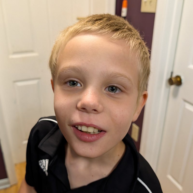 Thomas, age 10, smiling at the camera